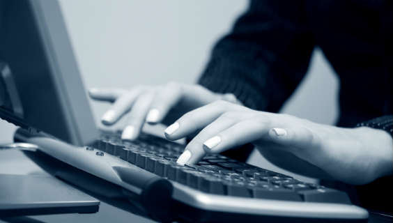 Hænder taster på computer 